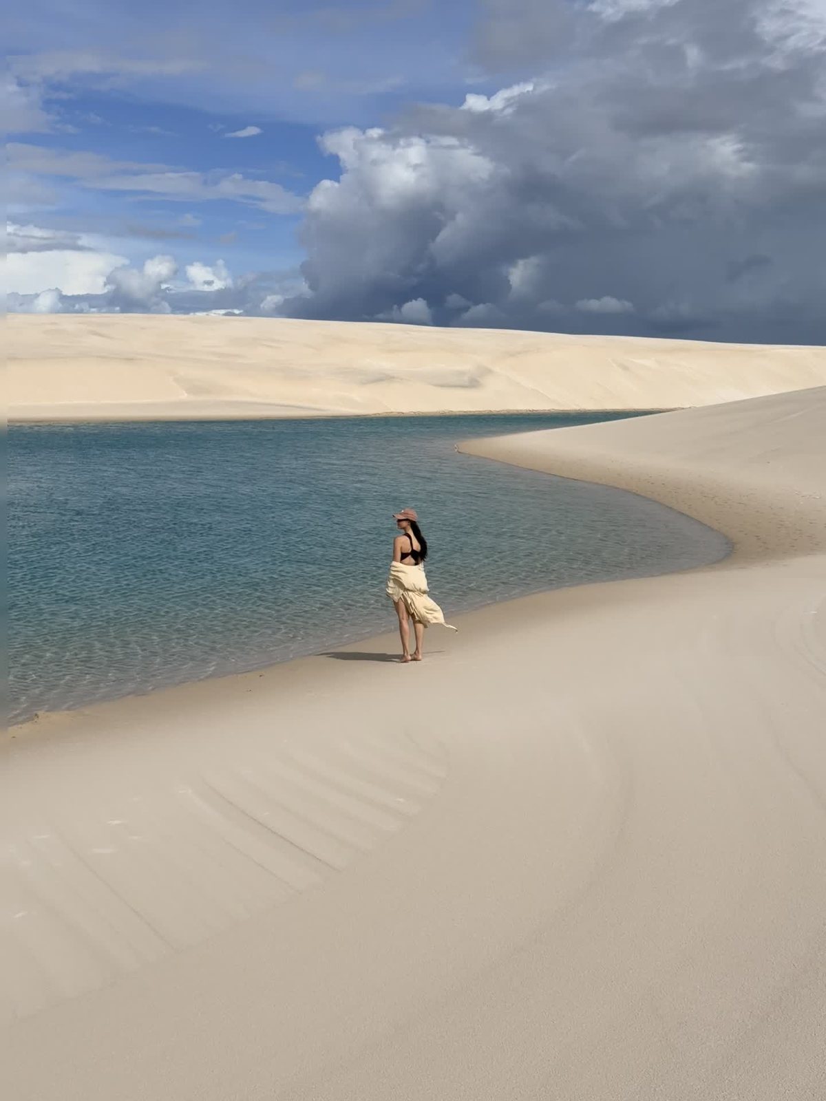 Miriã à beira de uma lagoa entre as dunas dos Lençóis Maranhenses